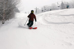 An image of Dylan skiing in some powder from Winter Storm Carrie on the Beech Seal trail at Bolton Valley Ski Resort in Vermont