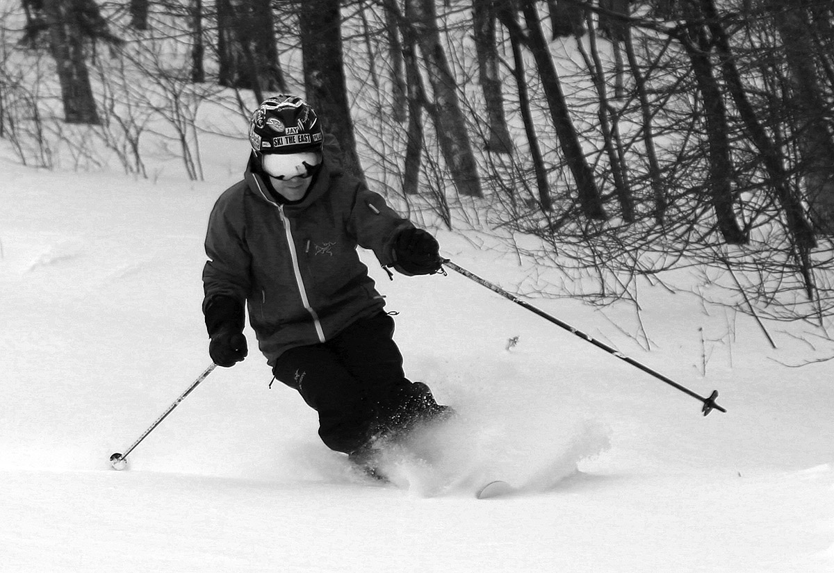 A black and white image of Jay skiing powder after Winter Storm Quinlan on the Spell Binder trail in the Timberline area of Bolton Valley Ski Resort in Vermont