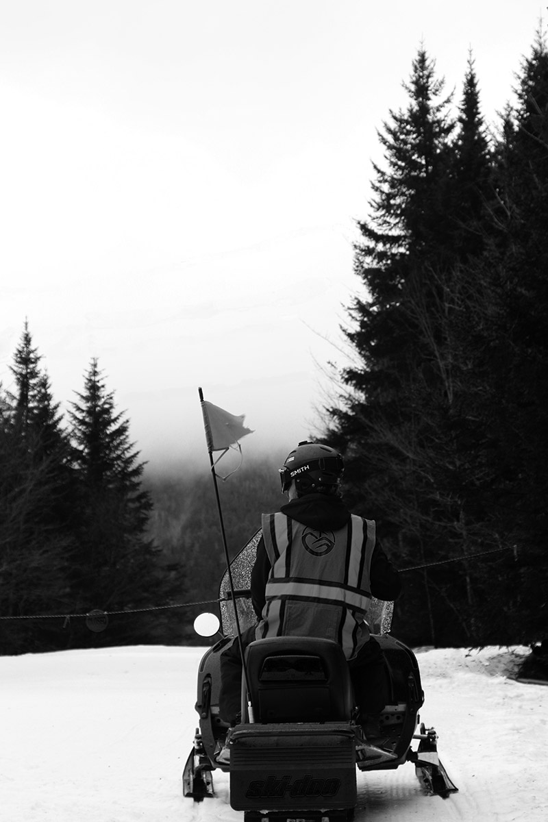 An image of a resort employee on a snowmobile in the Mid Mountain area of Bolton Valley Ski Resort in Vermont
