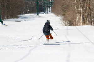 An image of Ty Telemark skiing in some powder on the Wilderness Lift Line area at Bolton Valley Ski Resort in Vermont