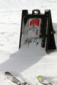 An image of a sign about ski touring with some fresh snow during a March snowstorm near the base area of Bolton Valley Ski Resort in Vermont