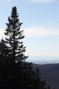 An image of a high-elevation view out toward Lake Champlain and the Champlain Valley on a May ski tour at Bolton Valley Ski Resort in Vermont