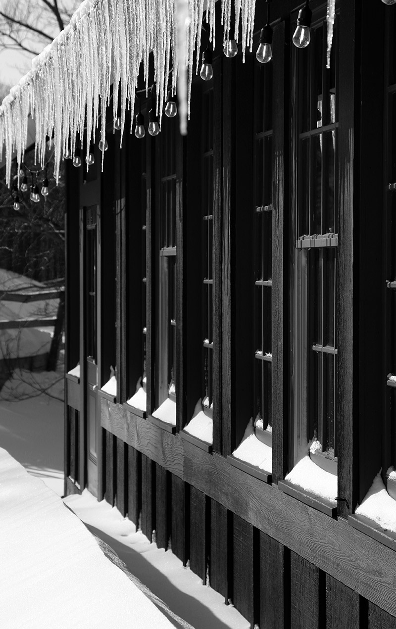 An image of icicles and accumulated snow below the roof overhang of the Timberline Base Lodge at Bolton Valley Ski Resort in Vermont