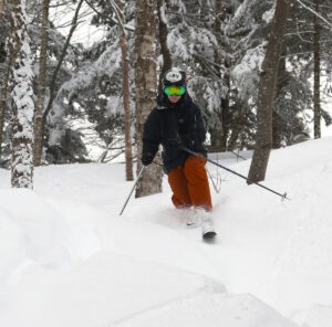 An image of Ty Telemark skiing in powder in the Bonus Woods area of the Snowflake Chair at Bolton Valley Resort in Vermont