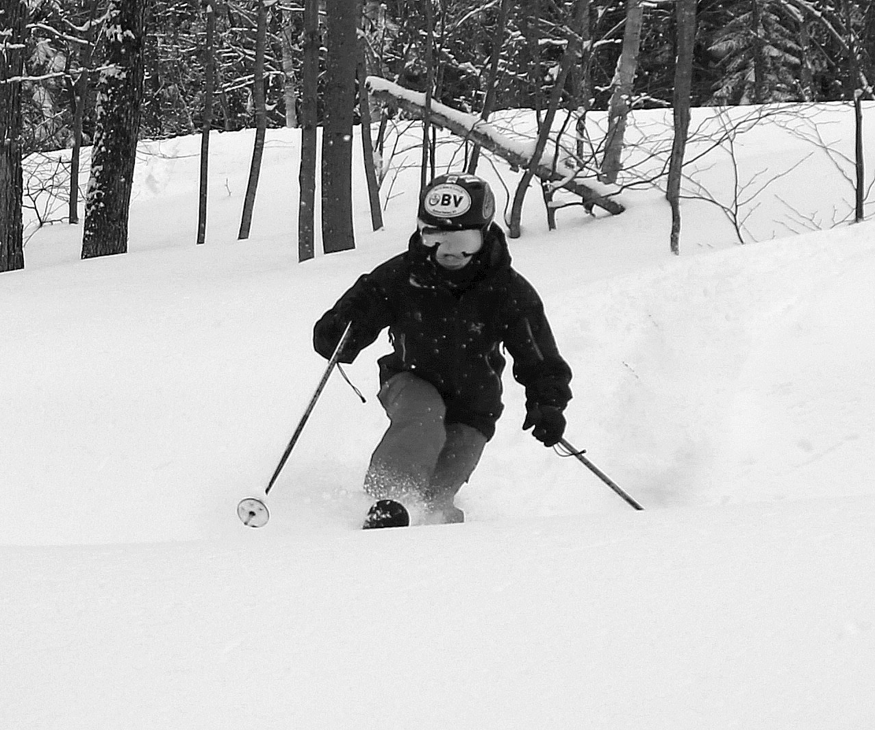 A black and white image of Ty Telemark skiing in powder after Winter Storm Quest in the Snowflake area of Bolton Valley Resort in Vermont