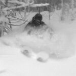 An image of Parker blasting through deep powder from Winter Storm Sage while skiing in the trees at Bolton Valley Ski Resort in Vermont