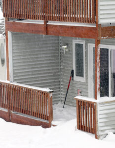An image of ski poles and drifted snow on one of the porches in a condominium at Bolton Valley Ski Resort in Vermont