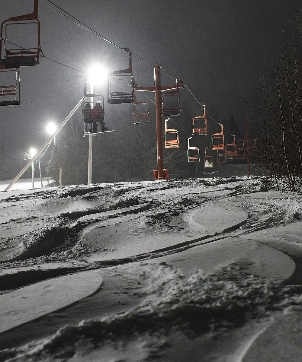 An image of ski tracks in powder snow from Winter Storm Uriel while night skiing under the lights at Bolton Valley Ski Resort in Vermont