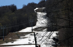 An image of the North Slope trail with some skiers hiking up for May turns at Stowe Mountain Resort on Mt. Mansfield in Vermont