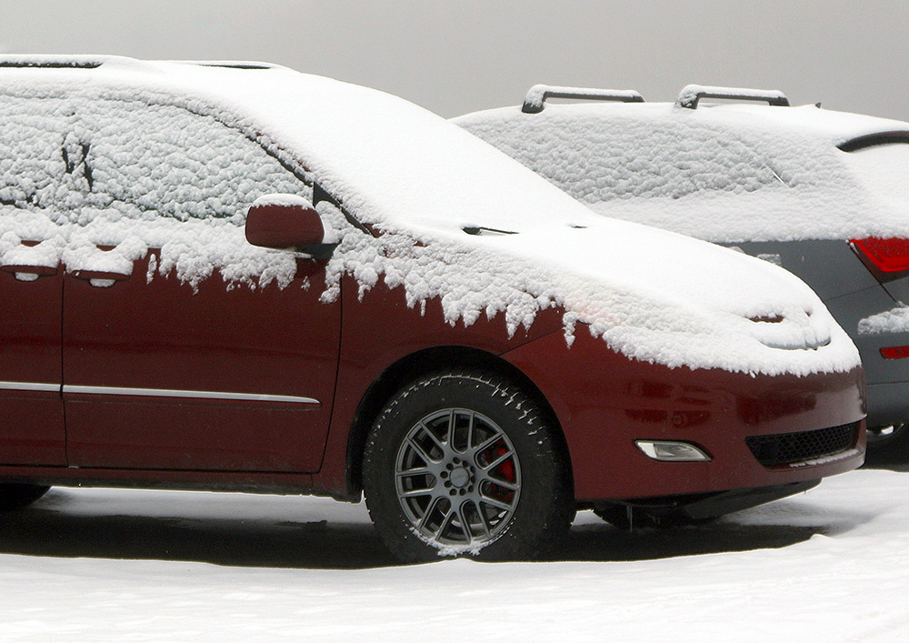 An image showing fresh snow atop some cars in one of the Village parking lots at Bolton Valley Ski Resort in Vermont after a mid-November snowfall