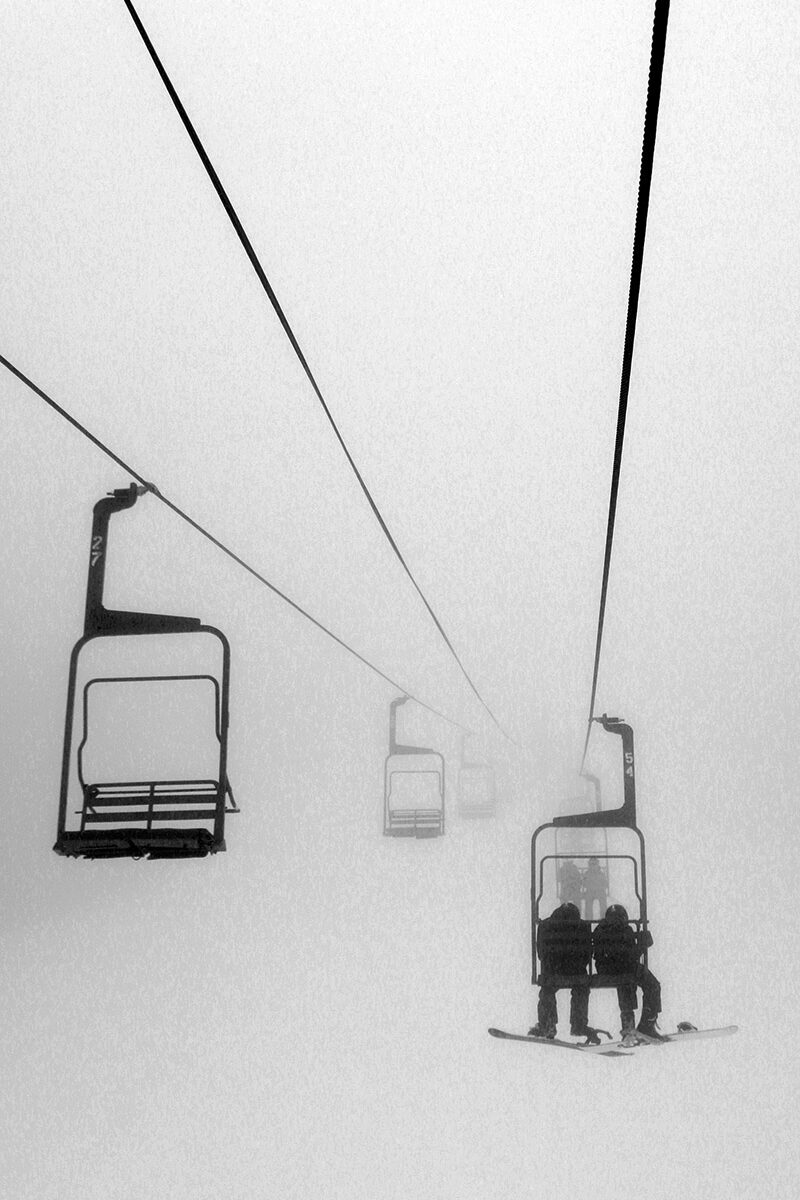 An image of the Mid Mountain Double Chairlift with low clouds and low visibility in early December at Bolton Valley Ski Resort in Vermont