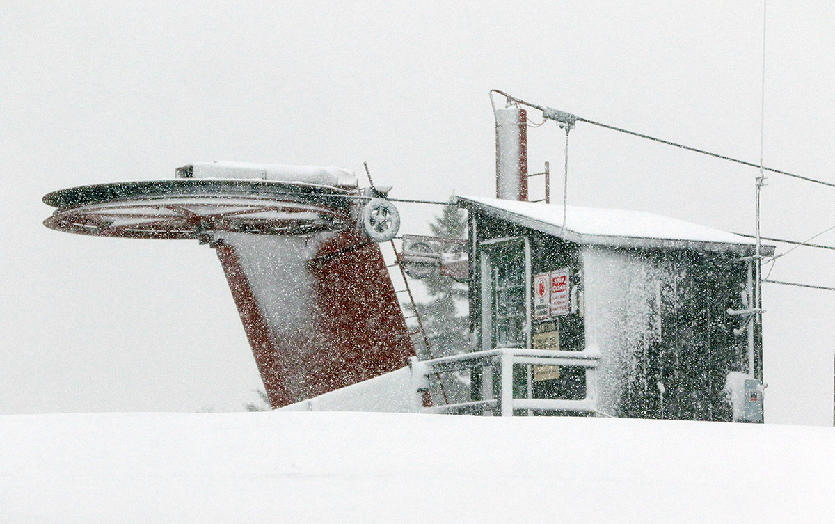 An image of the summit station of the Snowflake Double Chairlift during heavy snowfall from an ongoing December storm at Bolton Valley Ski Resort in Vermont