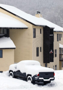 An image of fresh snow accumulations on a pickup truck and condominiums after early December storms affect the Village area at Bolton Valley Ski Resort in Vermont