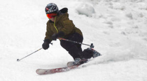 An image of Jay Telemark skiing in soft snow on the Hard Luck trail during the Christmas holiday week at Bolton Valley Resort in Vermont