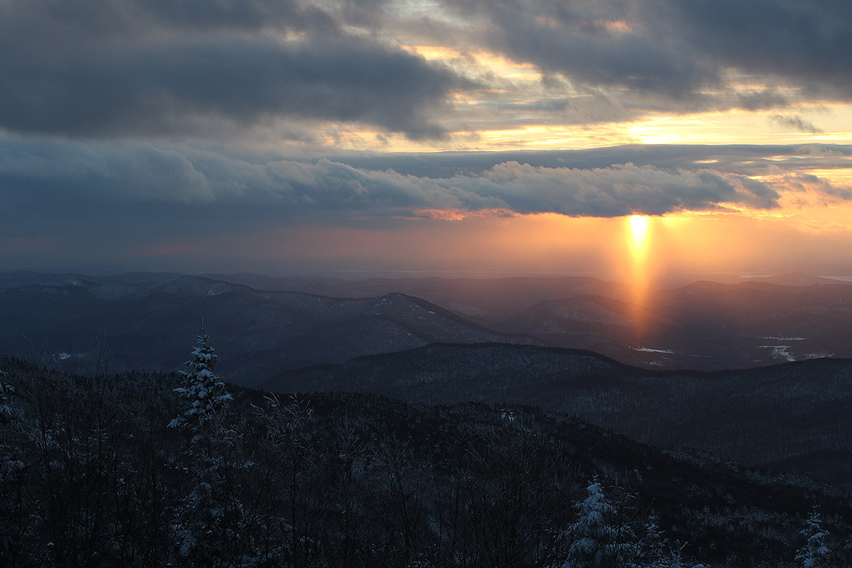 An image near sunset off to the west toward the Champlain Valley and the Adirondacks of New York from the Wilderness Summit during a ski tour at Bolton Valley Resort in Vermont
