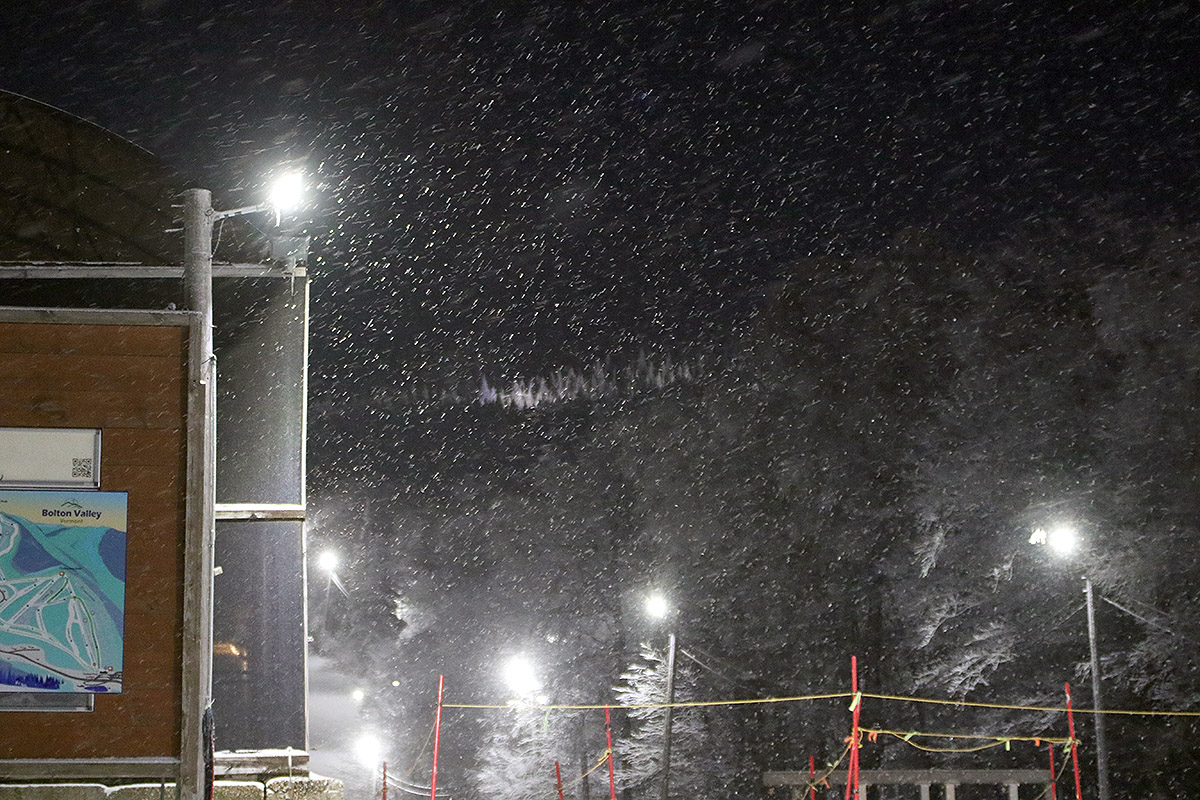 An image of snowflakes in the night skiing lights as a minor cold front passes through at Bolton Valley Ski Resort in Vermont