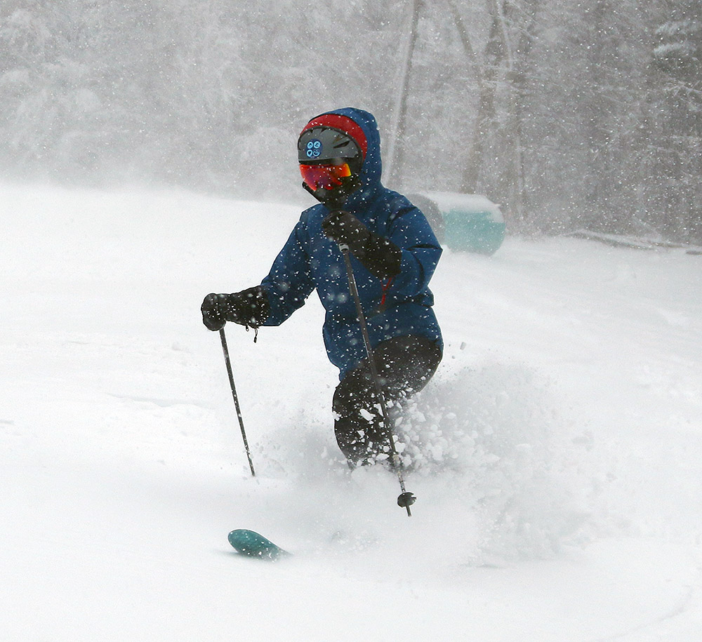 An image of Erica Telemark skiing in powder from the beginning of Winter Storm Ember in the Hide Away area at Bolton Valley Resort in Vermont