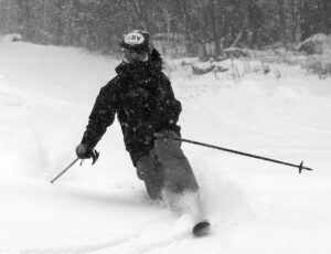 An image of Ty Telemark skiing in powder from the beginning of Winter Storm Ember in the Hide Away area at Bolton Valley Resort in Vermont