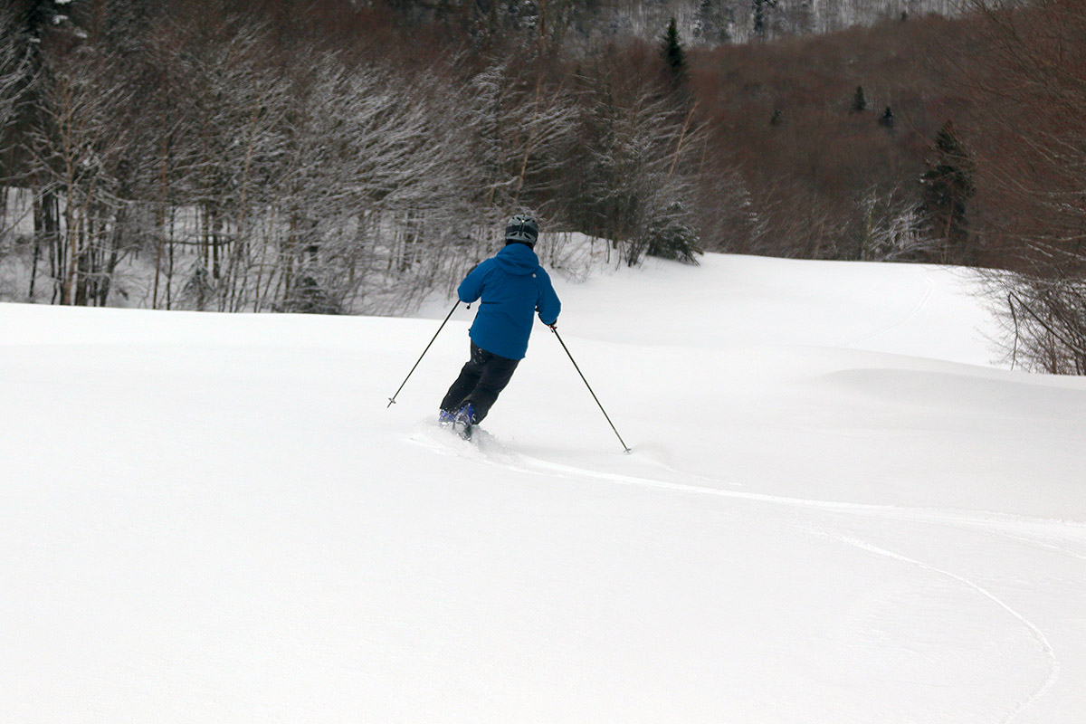 An image from behind of Erica Telemark skiing in untracked powder snow on the Lower Tattle Tale trail after Winter Storm Gerri hit Bolton Valley Ski Resort in Vermont
