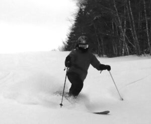 An image of Erica making Telemark turns in  untracked powder snow on the Snowflake Bentley trail after Winter Storm Gerri and Bolton Valley Ski Resort in Vermont