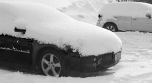 An image showing cars with snow in one of the Village parking lots at Bolton Valley Ski Resort in Vermont