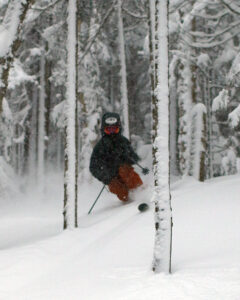 An image of Ty Telemark skiing in the trees near Maria's in fresh powder from Winter Storm Heather at Bolton Valley Ski Resort in Vermont