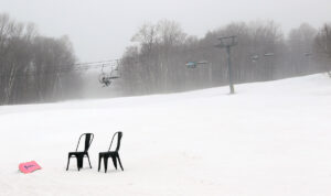 An image of the Timberline Quad Chairlift and the lower slopes of the Timberline area in early March at Bolton Valley Ski Resort in Vermont