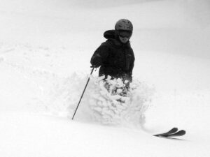 An image of Erica throwing up some March powder from a late winter storm while skiing at Bolton Valley Ski Resort in Vermont