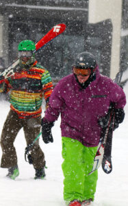 An image of Stephen and Johannes walking up from the base lodge to the bottom of the Vista Quad Chairlift amidst heavy snowfall from a February Alberta Clipper snowstorm at Bolton Valley Ski Resort in Vermont