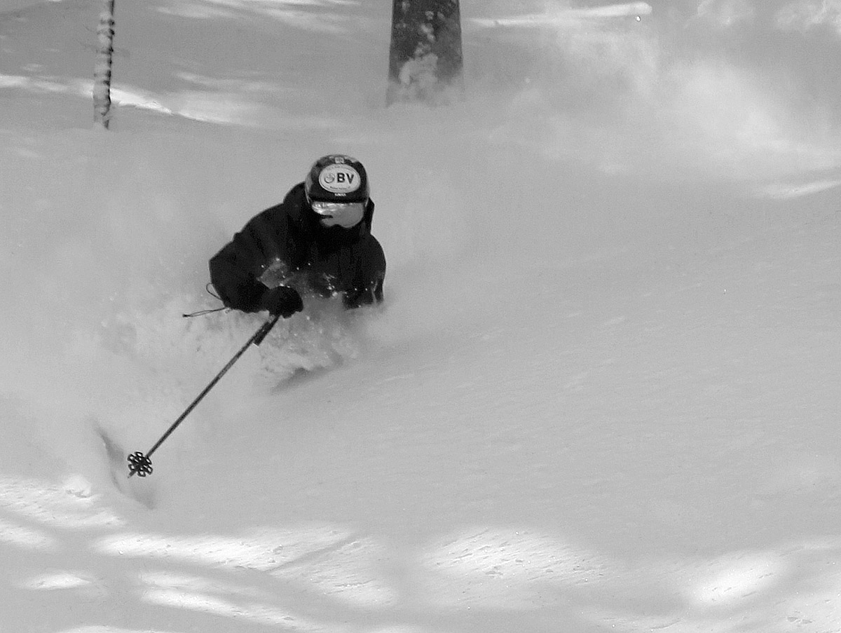 An image of Ty skiing in waist-deep powder after a March snowstorm at Bolton Valley Ski Resort in Vermont