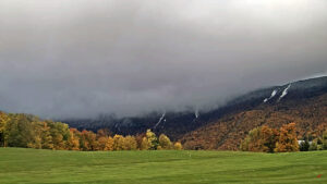 An image showing mid-October snow accumulations in the mountains as viewed from the golf course webcam at Sugarbush Ski Resort in Vermont