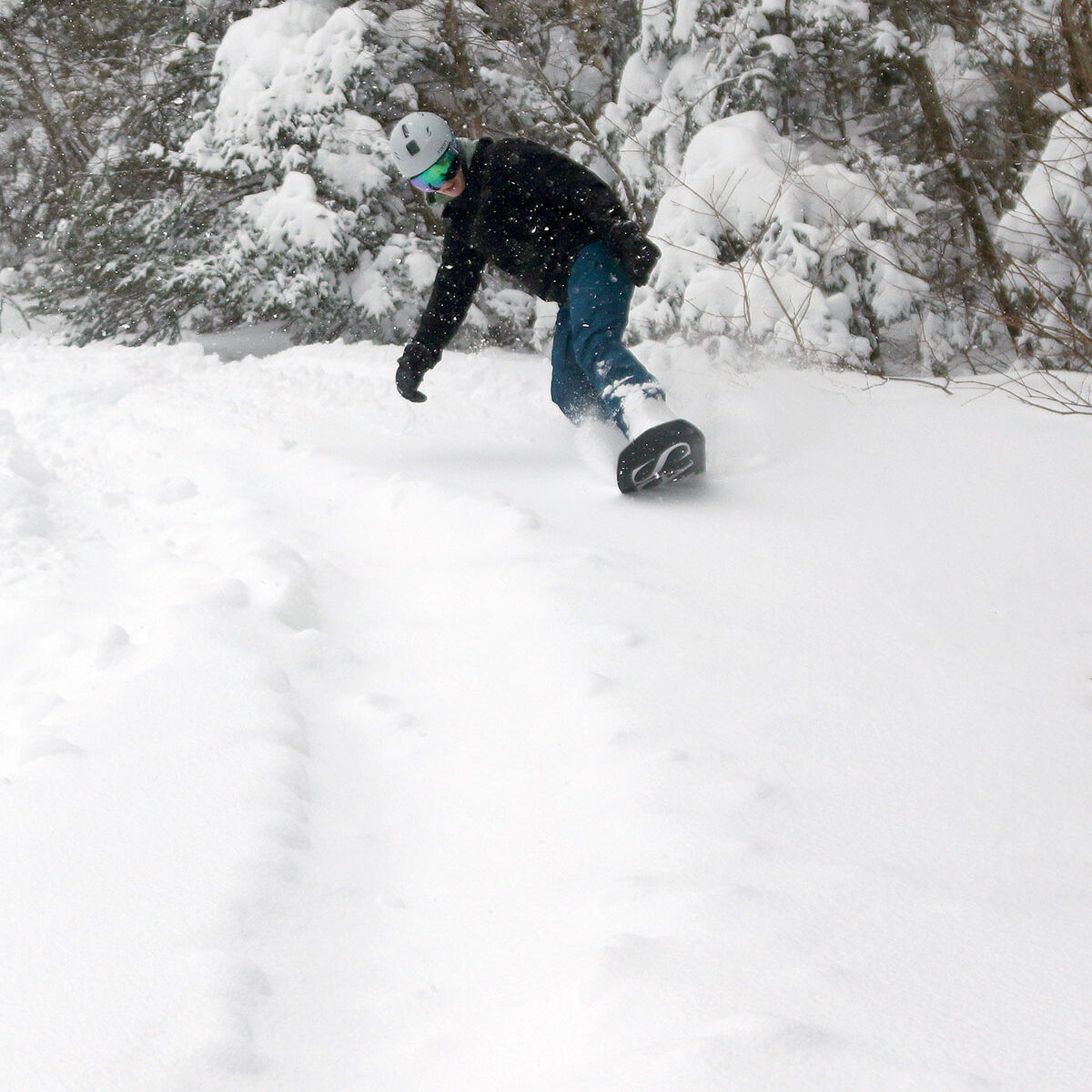 An image of Colin surfing through powder on his snowboard during Winter Storm Tormund in April 2024 at Bolton Valley Ski Resort in Vermont