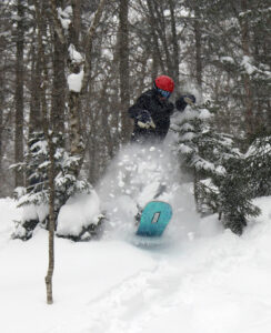 An image of Will blasting through powder snow between some trees during Winter Storm Ronnie at Bolton Valley Ski Resort in Vermont