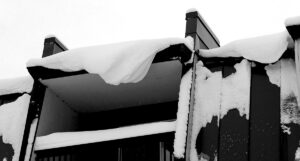 An image of snow curling off the roof of the Inn in the Village after several rounds of snow have affected Bolton Valley Resort in Vermont