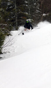 An image of Ty Telemark skiing in 20 inches of powder snow in early December on the Spell Binder Headwall at the Timberline area of Bolton Valley Ski Resort in Vermont