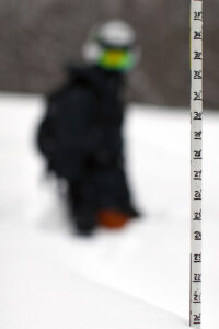 An image showing measurement of the snow depth during a ski tour of Timberline in early December at Bolton Valley Ski Resort in Vermont