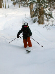 An image of Ty Telemark skiing in some powder snow in the Big Blue area of the Nordic and Backcountry Network of trails at Bolton Valley Ski Resort in Vermont