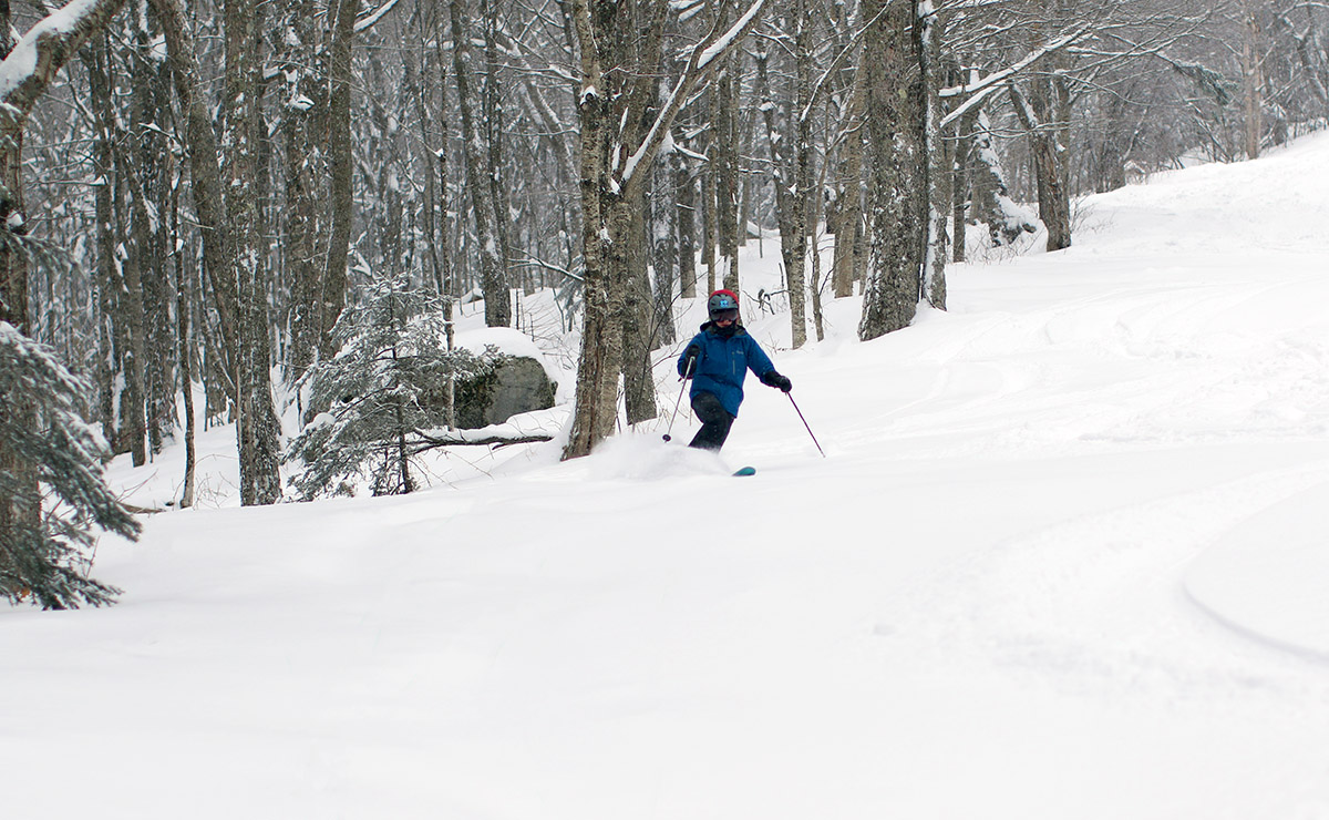 An image of Erica Telemark skiing in fresh powder in the Fanny Hill area of Bolton Valley Ski Resort in Vermont on Christmas Eve.