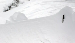 An image of a ski pole buried in a snow drift during the windy upslope portion of an early January winter storm cycle at Bolton valley Ski Resort in Vermont