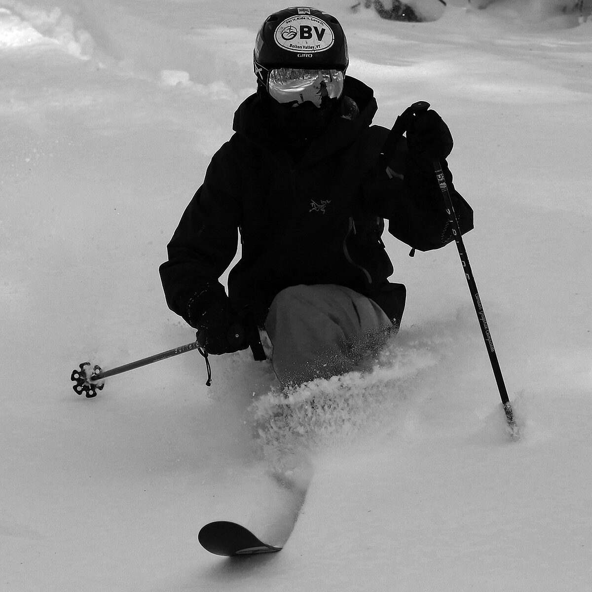 A black and white image of Ty Telemark skiing through light powder in the Snow Hole area of Bolton Valley Ski Resort in Vermont