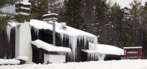 An image of the Omakase Asian fusion restaurant on Route 242 near Jay Peak in Vermont with snow on the roof and huge icicles hanging down to the ground.